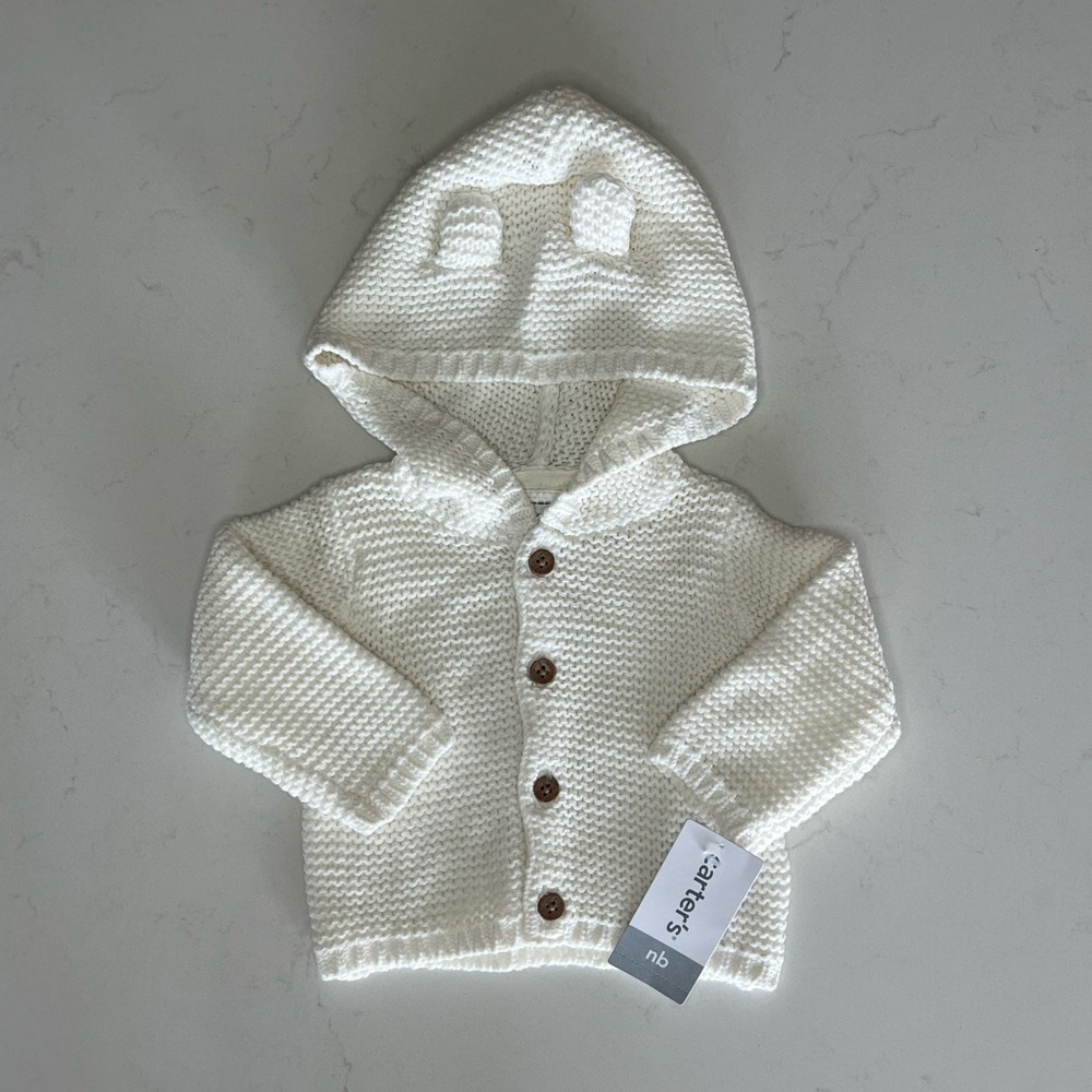 Carter’s cream colored button-up cardigan in newborn size.